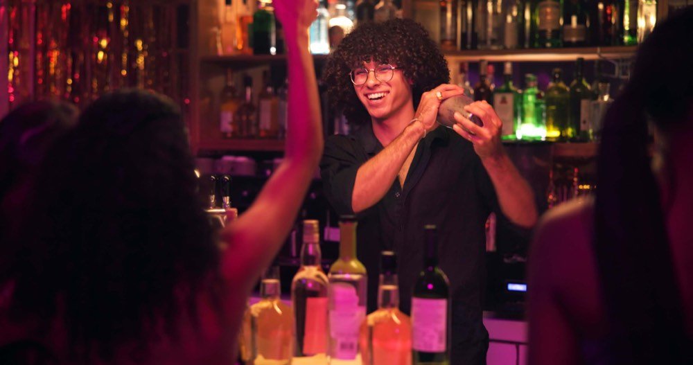 Bartender preparando cocteles en la barra de Cadena Cheers